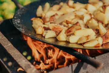 Fried Golden Potatoes on the grill. Cooking food in nature. Cooking food on fire.