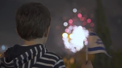 Litle boy looking at fireworks and Waving Israeli Flag, Israeli Boy looking at fireworks On  Independence Day,  Tel Aviv, Israel