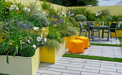 A colourful Courtyard garden used as an office recreation space with seating and raised flower borders