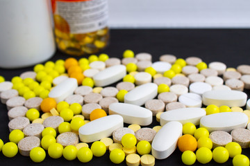 a lot of multi-colored tablets on a black background.