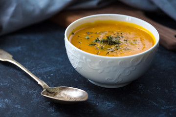 Pumpkin cream soup. Fresh soup with herbs on a background, Autumn concept. Tasty healthy food.