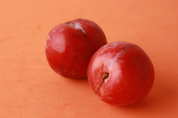 Delicious plums in colorful background