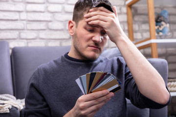 Man Looking At Too Many Credit Cards