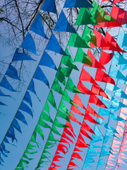 Carnival decorations, triangular flags against a blue sky