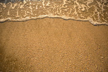The top corner of the beach has a sea of water coming to the shore