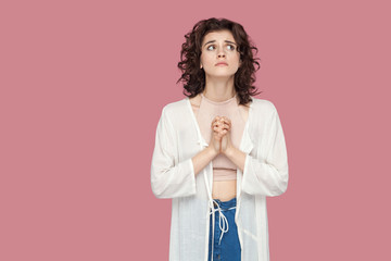 My God please help me. Portrait of worried hopeful beautiful brunette young woman with curly...