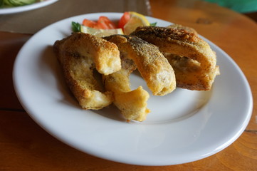 Pieces of fried fish on a porcelain plate.