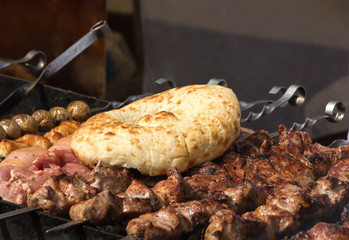 Shish kebab grilled meat and pita bread on skewers is fried on a brazier. Sunny summer day