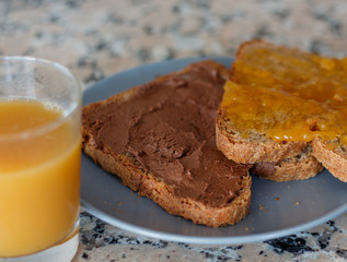 Slice toast with cocoa cream and peach jam on blue plate