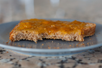 Thick toast with peach jam on blue plate