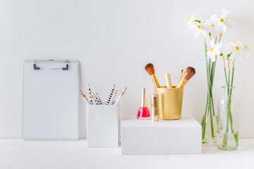 Home interior with decor elements. Mockup clipboard, white daffodils in a vase, cosmetic set