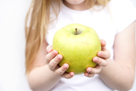 Big yellow green apple in children s hands on white background
