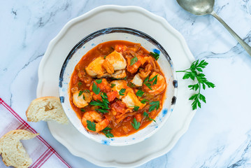 Tiger prawn and fish stew in a bowl- top view
