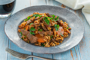 Giouvetsi - traditional Greek baked dish with beef and orzo pasta in tomato sauce.
