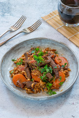 Fototapeta premium Giouvetsi - traditional Greek baked dish with beef and orzo pasta in tomato sauce - top view