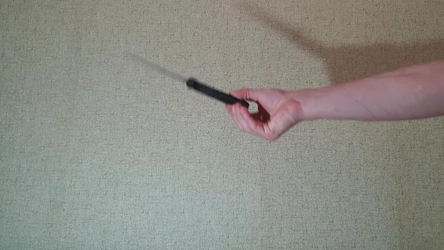 The man is twisting a knife in his hand slow motion.Knife in his hand.