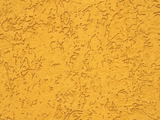 Decorative plaster of yellow color as a texture, background and pattern