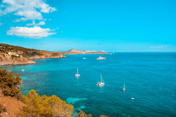 Fototapeta na wymiar Beautiful ocean coastline in Ibiza island, part of Balearic archipelago in Spain. Orange and teal view