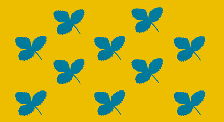 Leaves cut from blue paper on a yellow background. Pattern