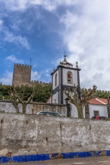 Fototapeta na wymiar View of the fortress and Luso Roman castle of Óbidos, catholic church and sky with clouds, in Portugal