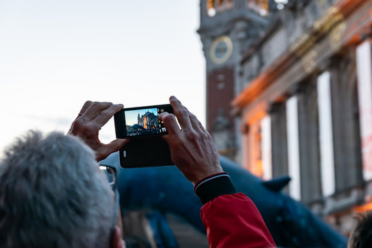 Man who makes videos and photos with a mobile phone on the great carnival parade.