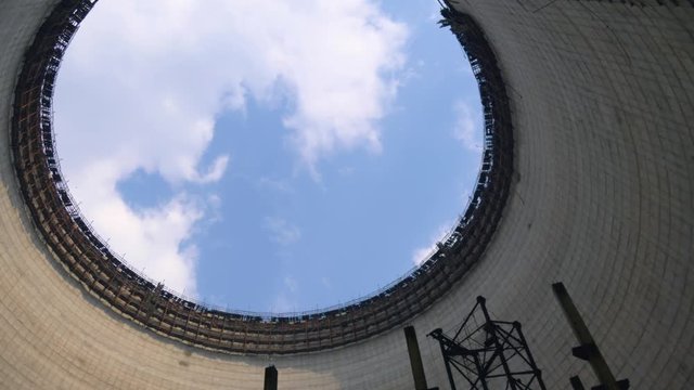 Cooling tower in exclusive zone. Chernobyl Cooling tower round construction, bottom-up view of the neck of tower. Blue clear sky with clouds, view from the cooling tower from the bottom up.