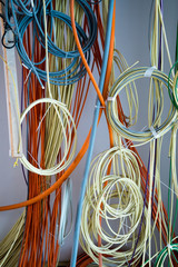 colorful electrical cables hanging from the ceiling in spirals and bundles