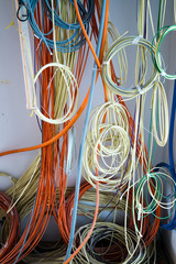 colorful electrical cables hanging from the ceiling in spirals and bundles