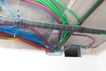 colorful plastic tubes for electrical wires in the sub ceiling in a massive wiring system