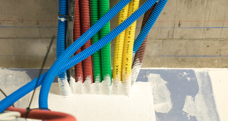 colorful plastic tubes for electrical wires in the sub ceiling in a massive wiring system