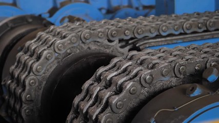 Chain gear. Machine with chain transmission at the factory. Close Up of machinery part. Industrial equipment. Metal chain and sprocket.