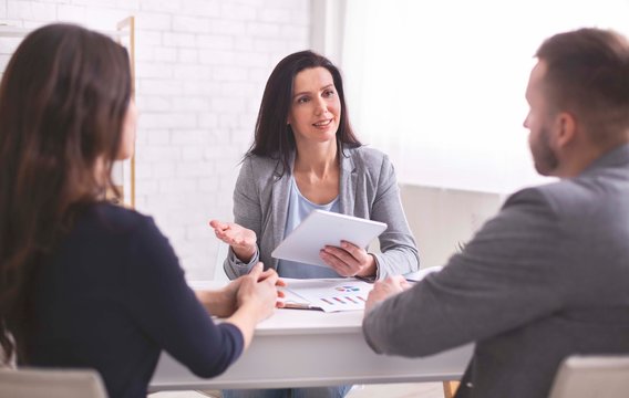 Professional woman talking to young couple at personal meeting