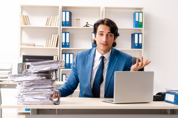 Young handsome busy employee sitting in office 