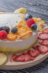 Dietary delicate fruity berry nut cake without baking. Wooden stand on a black table.
