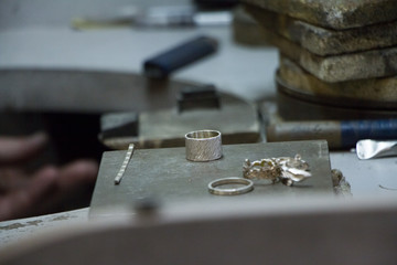 Closeup of blank for manual production of silver rings and earrings by master jeweler