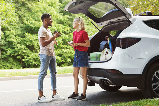 Multicultural couple standing near car - Powered by Adobe