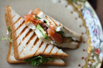 Closeup of sandwich with smoked salmon creamcheese and greens on a beautiful plate