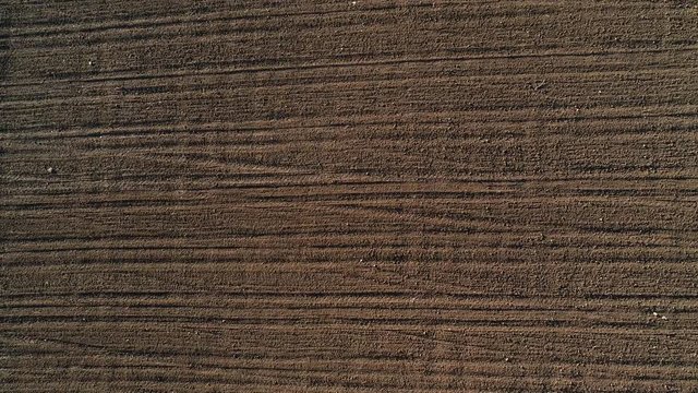 Drone clip of furrows row pattern in a plowed field prepared for planting crops in spring.
