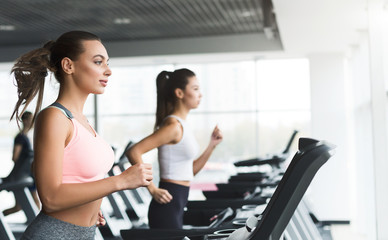 Fototapeta na wymiar Fit girls doing cardio training on treadmill