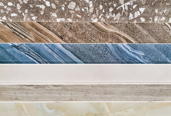 A stack of multi-colored marble slabs. Samples of decorative facing stone close-up. Beautiful colorful stone wall background. Selective focus