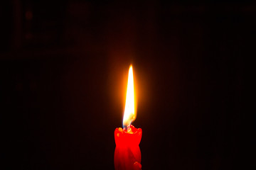 Red burning candle in the dark - mystery and romance, time of love and passion