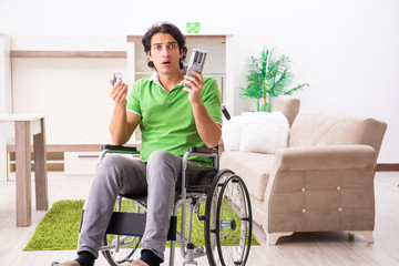 Young handsome man in wheelchair at home 