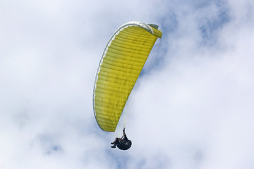 Paraglider flying yellow wing