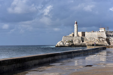 Fototapeta premium Big waves hitting Malecon, Havana, Cuba and Morro Castle at the background, Havana, Cuba
