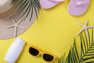 Beach accessories on yellow background