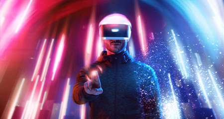 Model young man with beard in glasses of virtual reality. Augmented reality, science, future technology, people concept. VR. Futuristic 3d glasses with virtual projection. Neon blue, pink light.