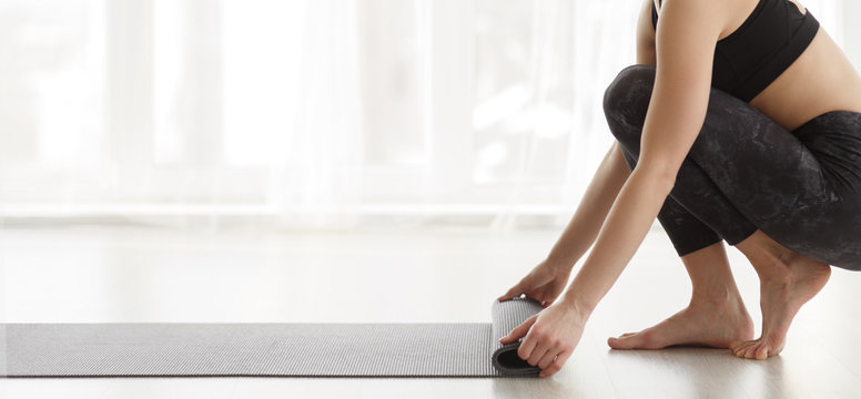 Woman Rolling Mat After Yoga Training, Panorama