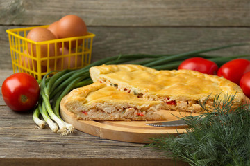 Pies with meat and onions on a cutting board.
