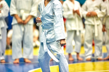 Naklejka premium Concept karate, martial arts. Concept of leadership, victory, martial arts. The fighter performs exercises in front of a group of fighters.