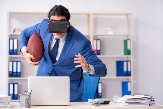 Young handsome businessman playing rugby with virtual glasses